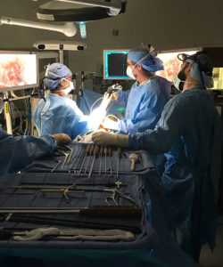 Team of surgeons performing video-assisted spine surgery.