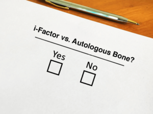 Photo illustration showing sheet of paper reading i-factor vs autologous bone? With Yes No. checkboxes.