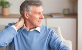 Senior male massaging neck during his ache.